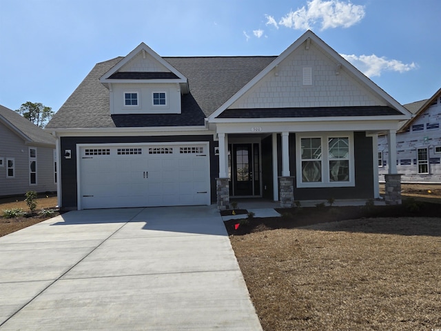 craftsman house featuring a garage, concrete driveway, and a shingled roof