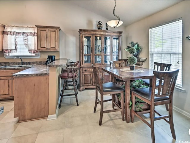 tiled dining area with lofted ceiling and sink