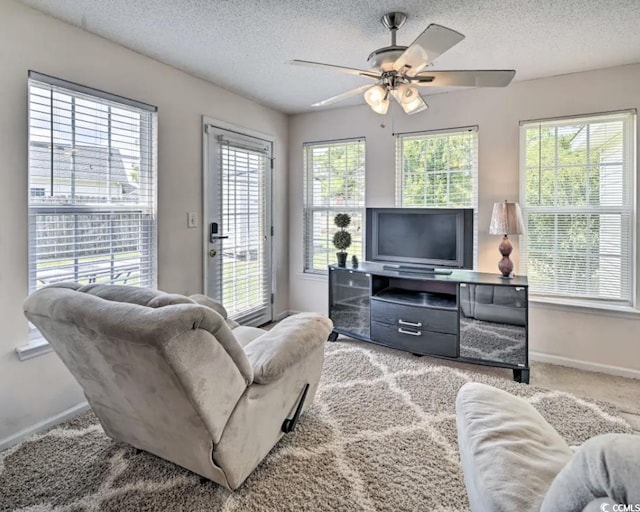 living room with ceiling fan, a textured ceiling, and carpet flooring