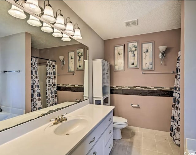 bathroom featuring vanity, walk in shower, toilet, tile patterned floors, and a textured ceiling