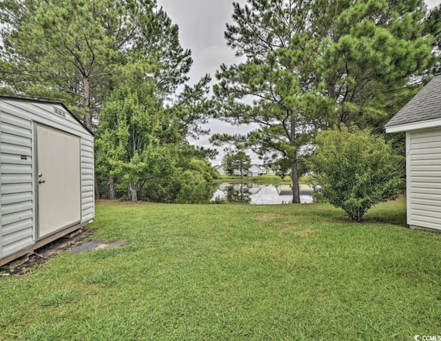 view of yard featuring a storage shed and a water view