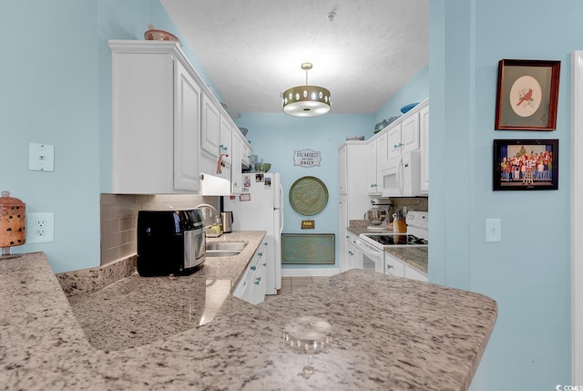 kitchen featuring white cabinetry, white appliances, a textured ceiling, and tasteful backsplash