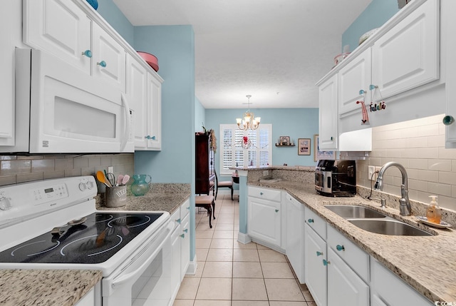 kitchen with white cabinetry, sink, hanging light fixtures, a chandelier, and white appliances