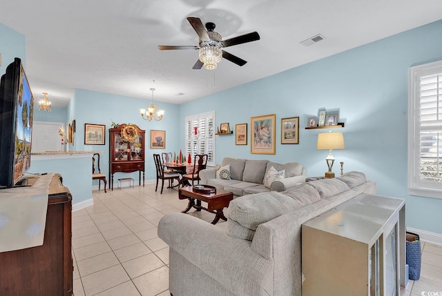 living room featuring ceiling fan with notable chandelier and light tile patterned flooring