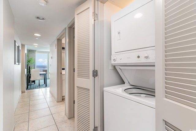 washroom featuring light tile patterned floors and stacked washer and clothes dryer