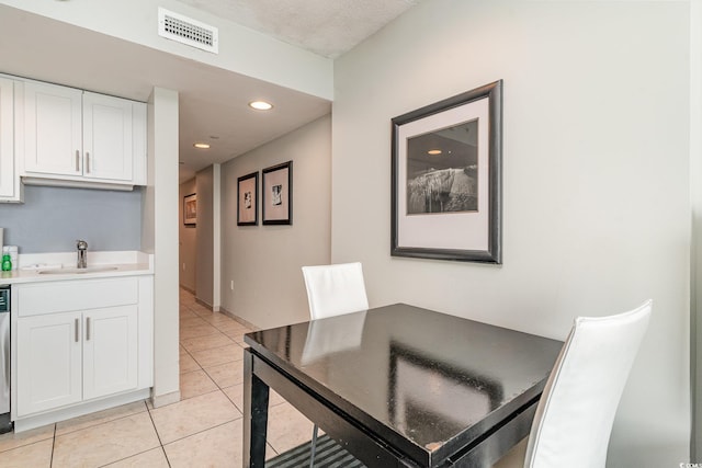 dining area featuring sink and light tile patterned flooring