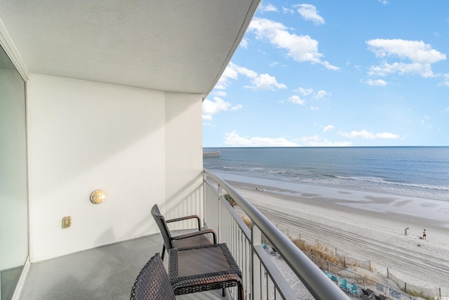 balcony with a water view and a beach view