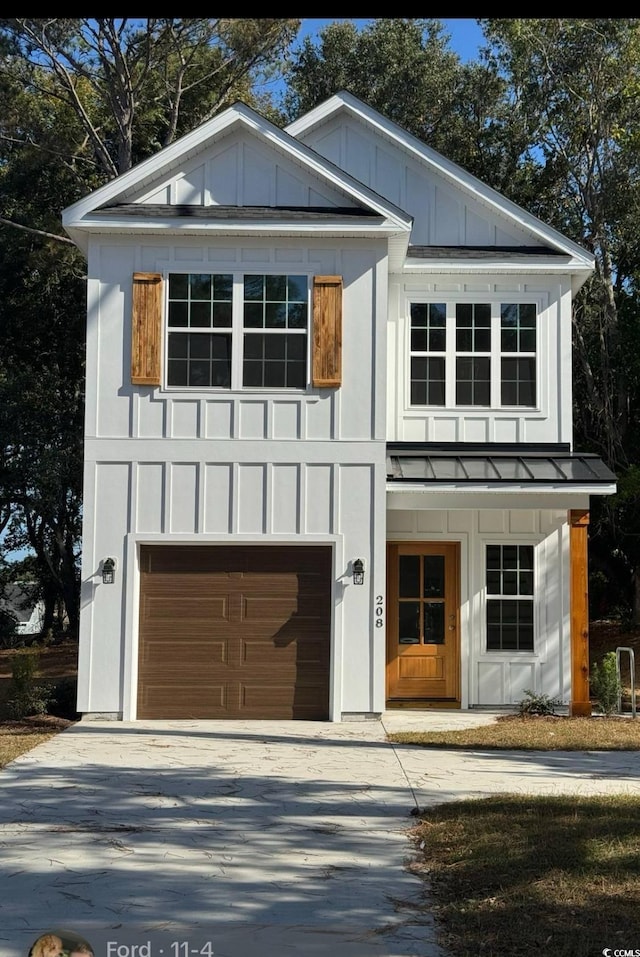 view of front of home with board and batten siding, a standing seam roof, driveway, and an attached garage