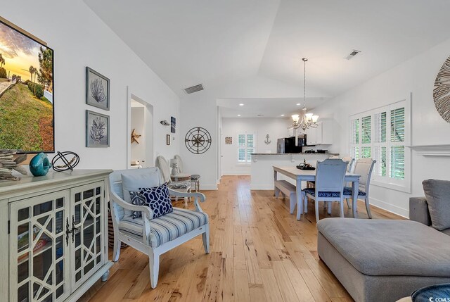 613 Lee Ave, Murrells Inlet, SC 29576 - living room featuring a chandelier, lofted ceiling, light wood-style flooring, plenty of natural light, and baseboards