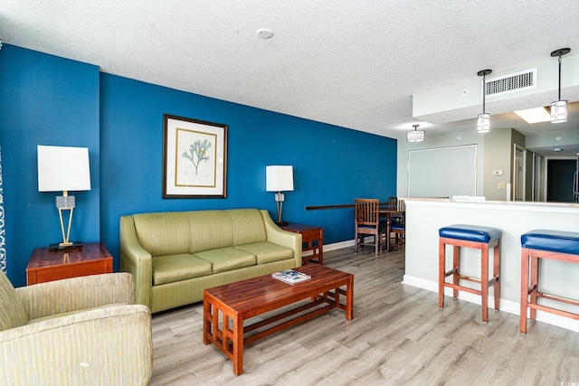 living room with light hardwood / wood-style floors and a textured ceiling