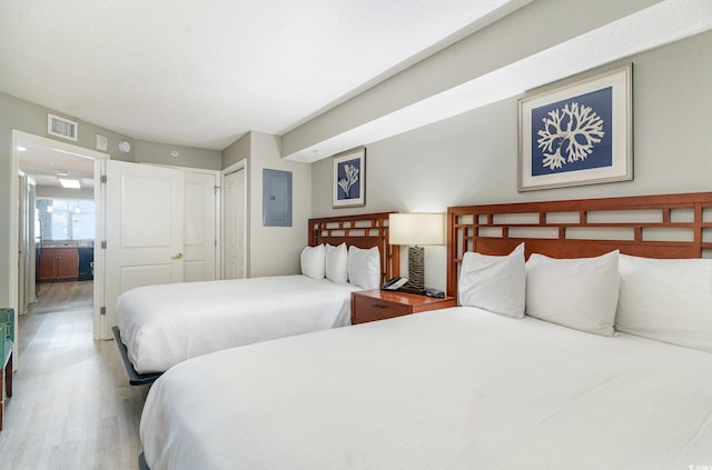 bedroom featuring electric panel, a closet, and hardwood / wood-style flooring