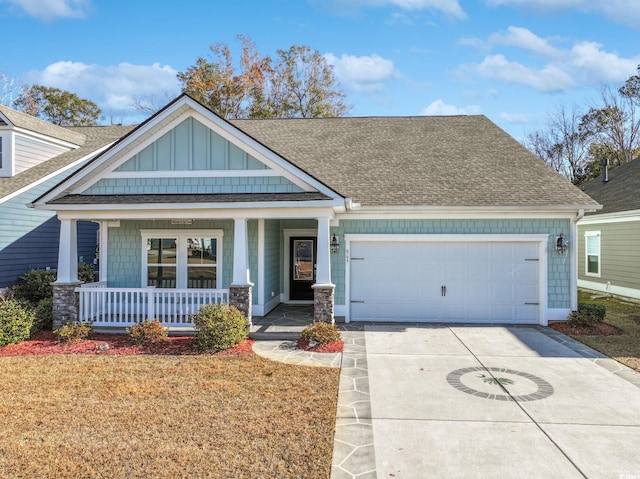 craftsman inspired home with covered porch, a front yard, and a garage