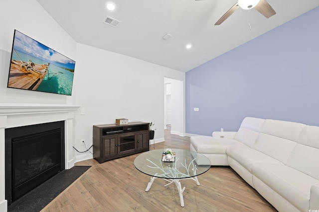 living room with light hardwood / wood-style floors, lofted ceiling, and ceiling fan