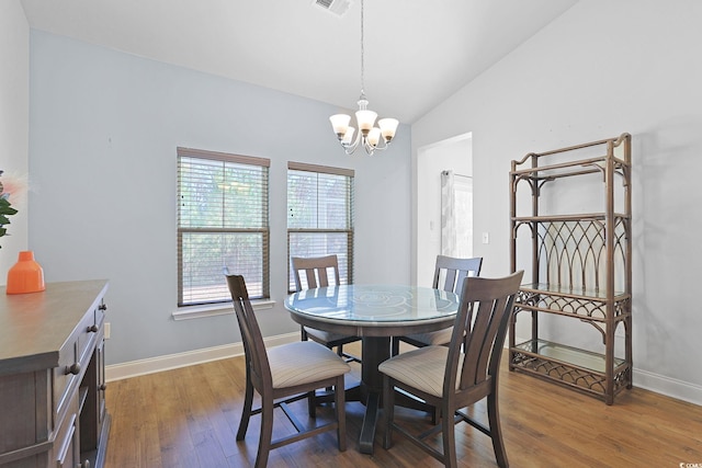 dining area with a chandelier, lofted ceiling, and dark hardwood / wood-style floors