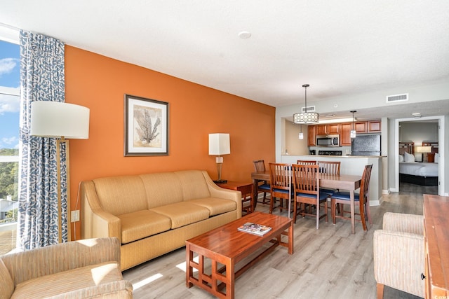 living room with light hardwood / wood-style floors and a textured ceiling