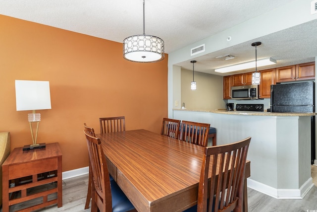 dining area featuring hardwood / wood-style floors and a textured ceiling