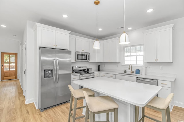 210 26th Ave S, Myrtle Beach, SC 29577 - kitchen with a breakfast bar, a sink, light wood-type flooring, a center island, and appliances with stainless steel finishes