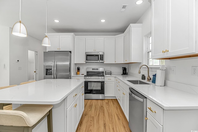 210 26th Ave S, Myrtle Beach, SC 29577 - kitchen featuring a center island, a sink, light wood-style floors, white cabinets, and appliances with stainless steel finishes