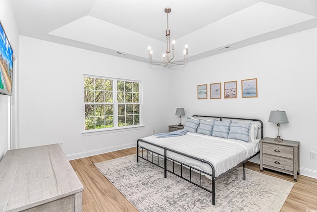 210 26th Ave S, Myrtle Beach, SC 29577 - bedroom featuring a tray ceiling, light wood-type flooring, baseboards, visible vents, and a notable chandelier