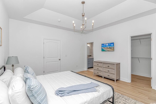 210 26th Ave S, Myrtle Beach, SC 29577 - bedroom featuring a spacious closet, an inviting chandelier, a closet, baseboards, and light wood-style flooring