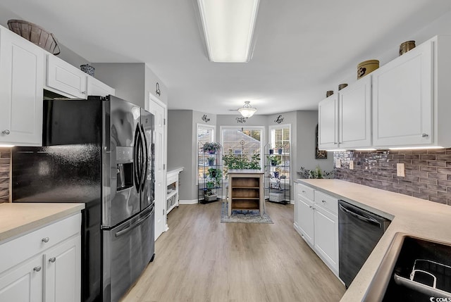 kitchen with white cabinetry, light wood-type flooring, decorative backsplash, and black appliances