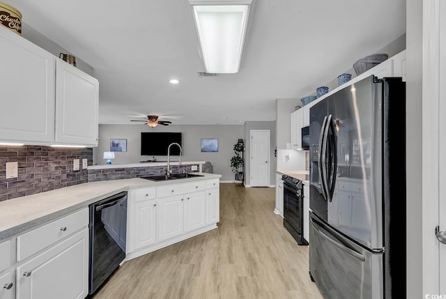 kitchen with tasteful backsplash, white cabinetry, sink, and black appliances