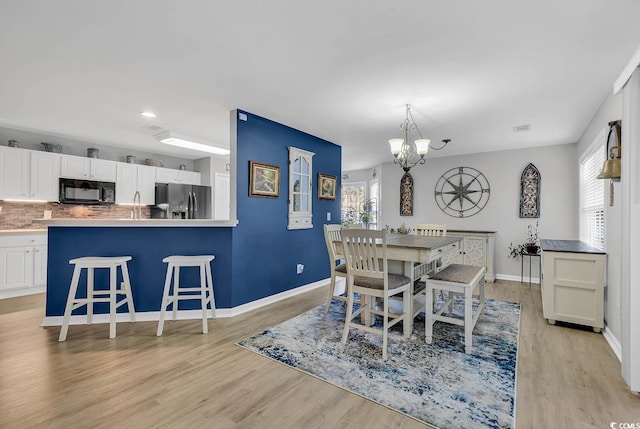 dining space with a chandelier and light hardwood / wood-style flooring