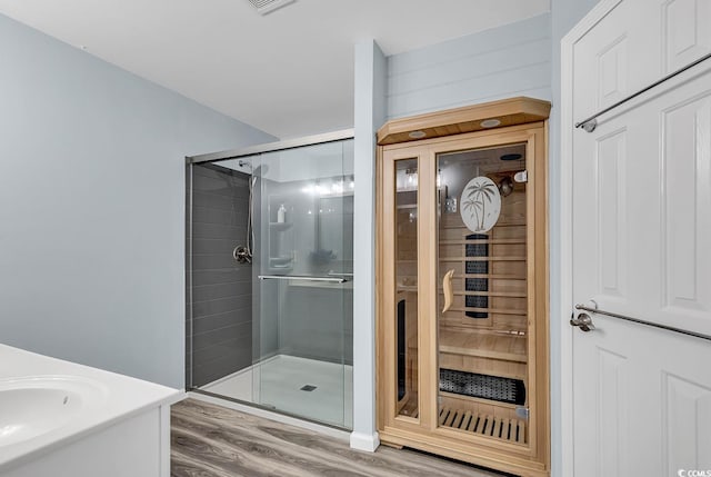 bathroom featuring walk in shower, sink, and hardwood / wood-style flooring