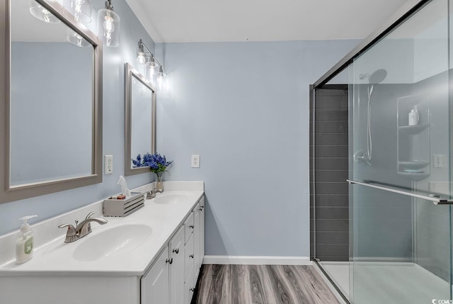 bathroom featuring vanity, an enclosed shower, and wood-type flooring