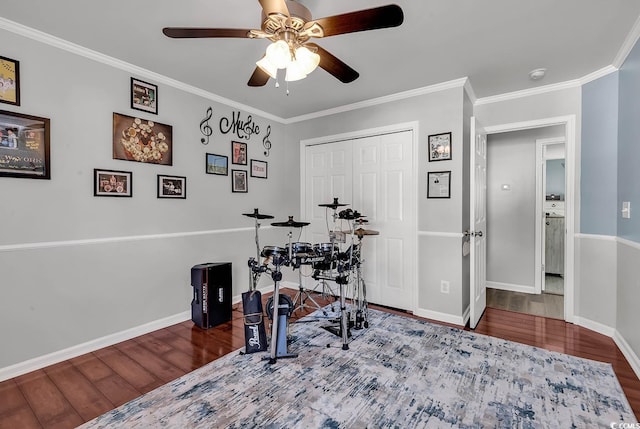 exercise area featuring hardwood / wood-style flooring, ceiling fan, and crown molding