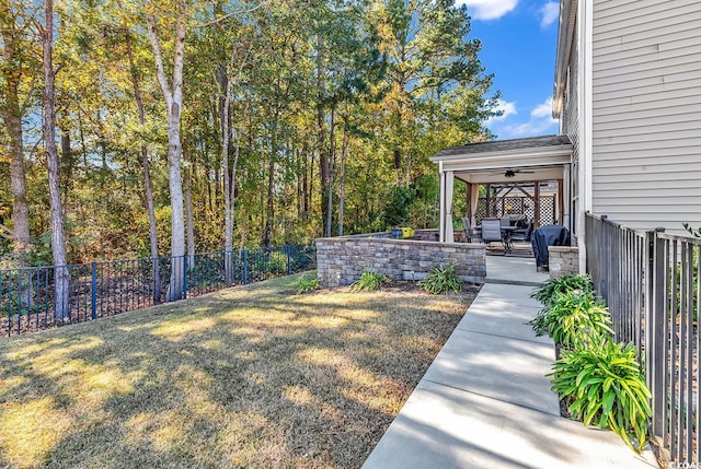 view of yard featuring ceiling fan and a patio area