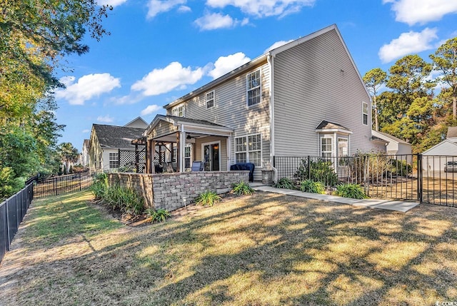 back of property with a yard and ceiling fan