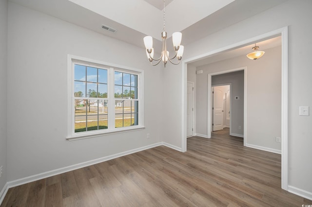 empty room featuring hardwood / wood-style floors and an inviting chandelier