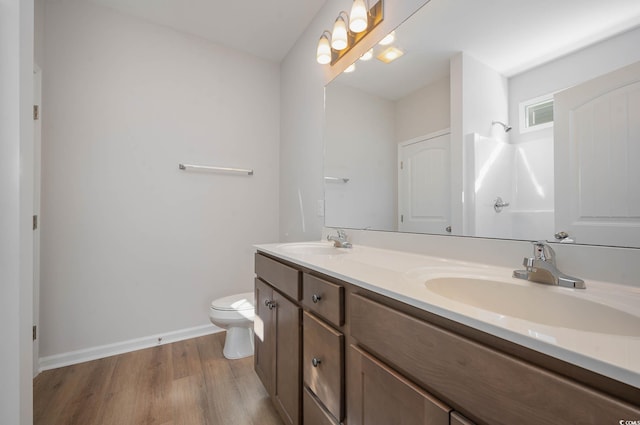 bathroom featuring hardwood / wood-style flooring, vanity, a shower, and toilet