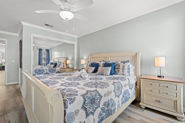 bedroom featuring ceiling fan, a closet, ornamental molding, and light hardwood / wood-style flooring