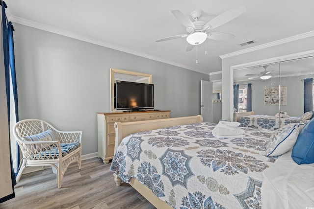 bedroom featuring light wood-type flooring, a closet, ceiling fan, and ornamental molding