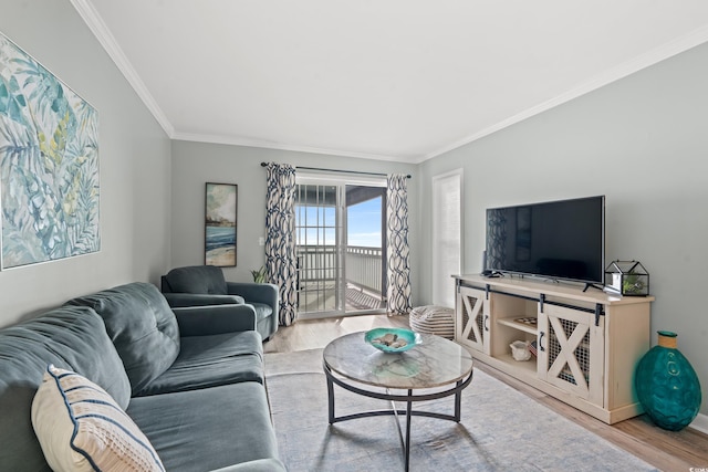 living room with ornamental molding and light hardwood / wood-style flooring