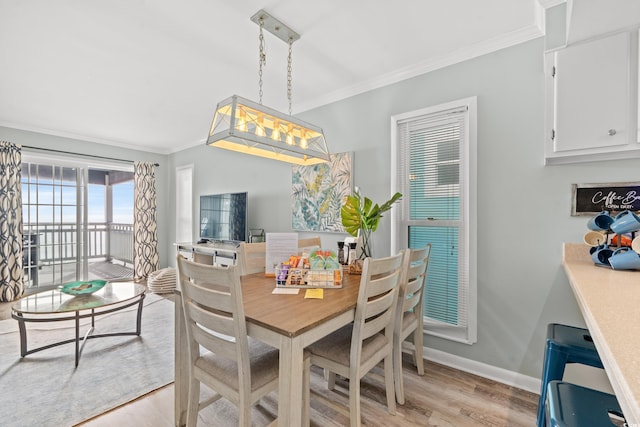 dining room featuring light wood-type flooring and ornamental molding