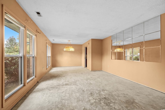 carpeted empty room with a textured ceiling