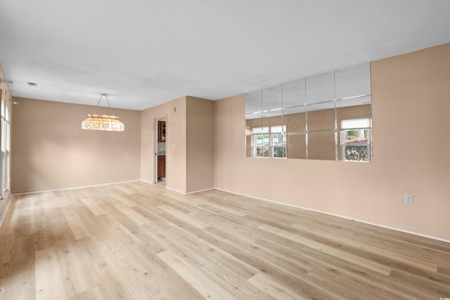 unfurnished room with light wood finished floors and baseboards