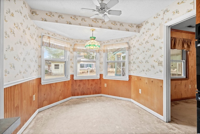 spare room featuring ceiling fan, carpet floors, and a textured ceiling