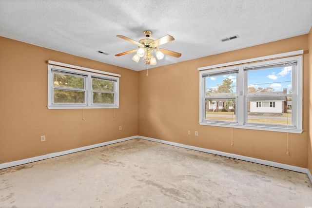 unfurnished room with ceiling fan, concrete flooring, and a textured ceiling