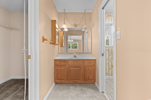 bathroom featuring a healthy amount of sunlight, vanity, and baseboards