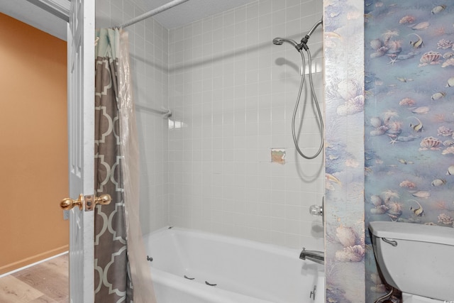 full bathroom featuring baseboards, shower / bathtub combination with curtain, wood finished floors, and toilet
