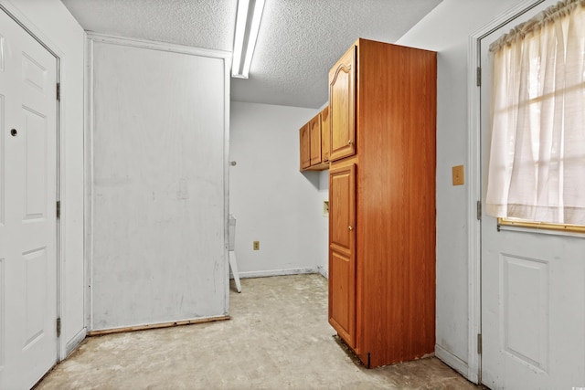 clothes washing area with a textured ceiling