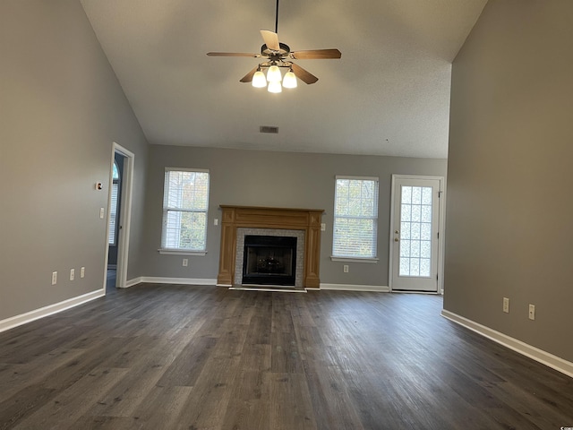 unfurnished living room with ceiling fan, dark hardwood / wood-style floors, a tile fireplace, and high vaulted ceiling