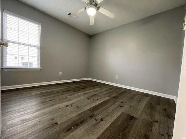 empty room with ceiling fan and dark wood-type flooring