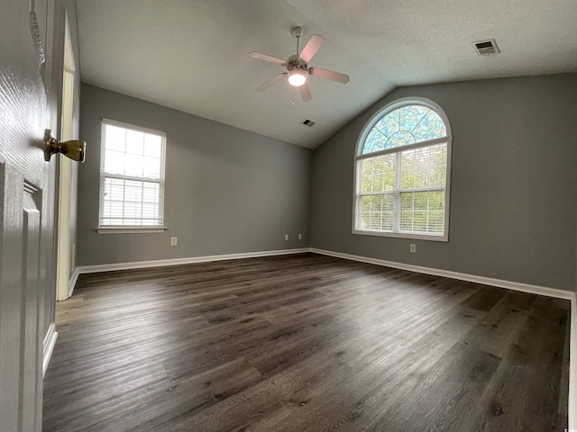 spare room with vaulted ceiling, ceiling fan, dark hardwood / wood-style flooring, and a textured ceiling