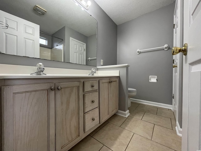 bathroom with toilet, tile patterned floors, walk in shower, a textured ceiling, and vanity