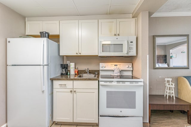 kitchen featuring white cabinetry, sink, and white appliances